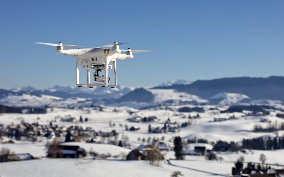 Free Image of Large White Remote Controlled Drone Flying Over Snow Covered Field 