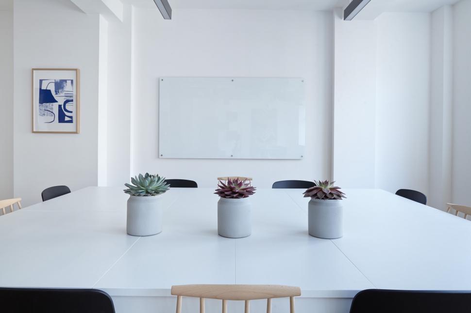 Free Image of White Table With Black Chairs and White Board 