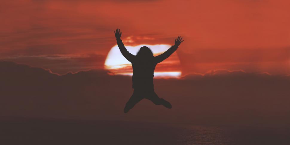 Free Image of Person Jumping in the Air With Arms Raised 