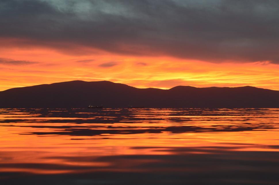 Free Image of Majestic Sunset Over Water and Mountains 