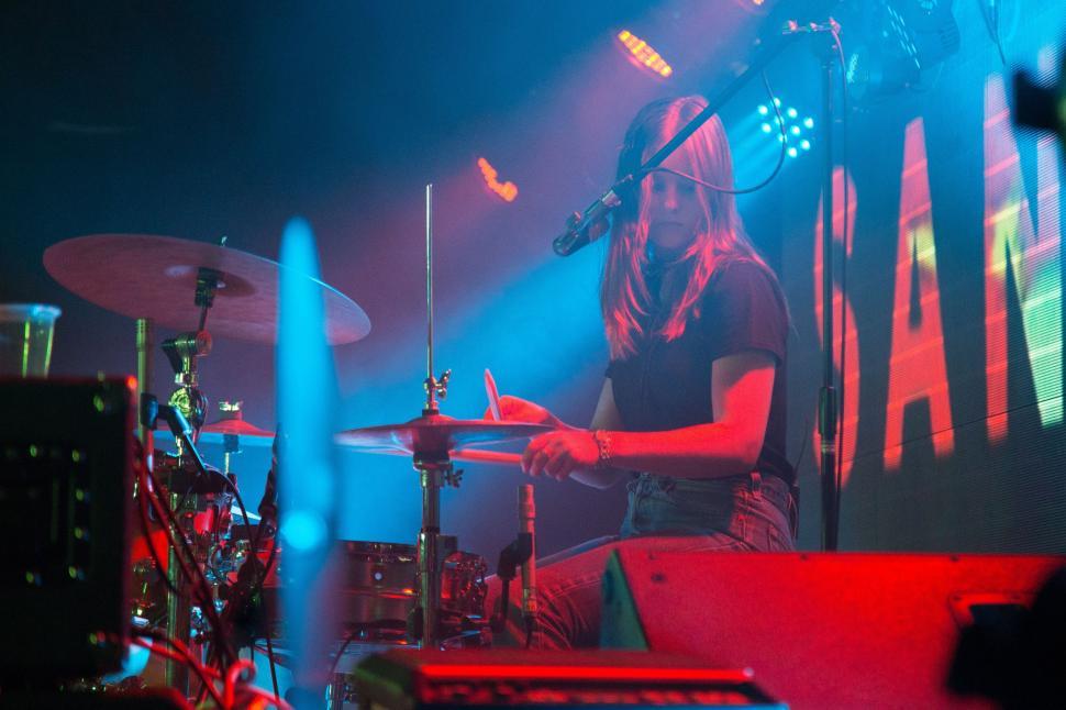 Free Image of Long-Haired Man Playing Drums on Stage 