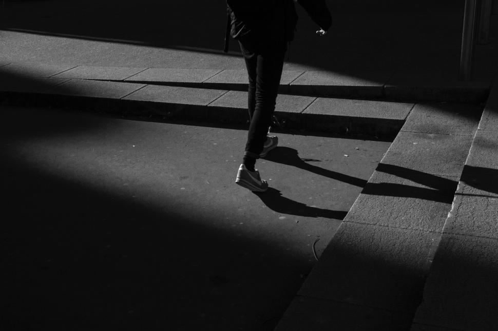 Free Image of Person Walking Down Sidewalk in the Dark 