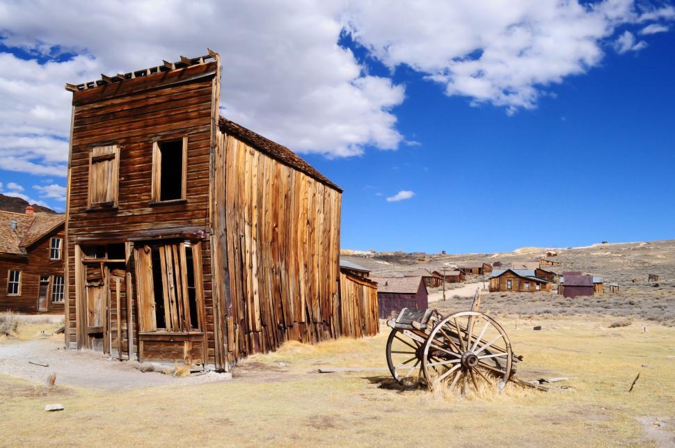 Free Image of Old Wooden Building With Wagon in Front 