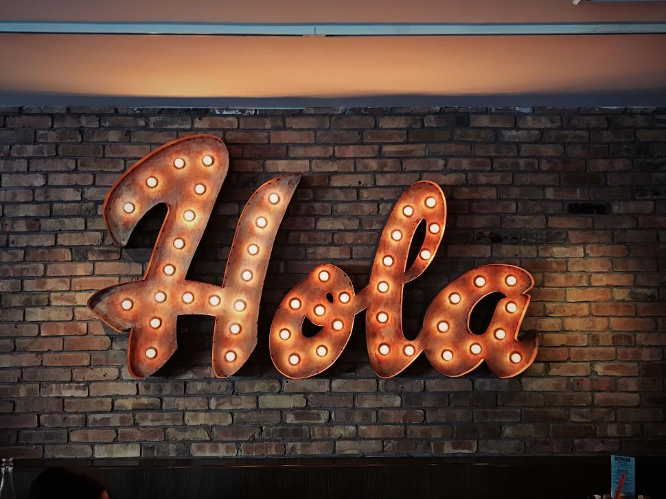 Free Image of Brick Wall With Sign Saying Hola 