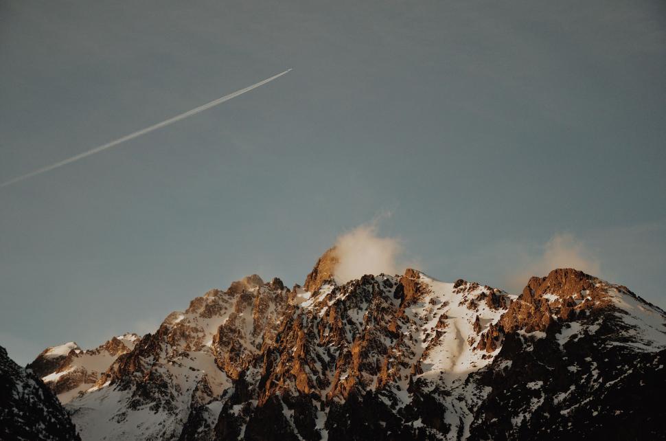 Free Image of A Plane Flying Over a Mountain Range 
