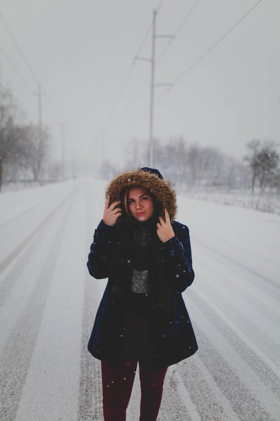Free Image of Woman Walking Down a Snow Covered Road 