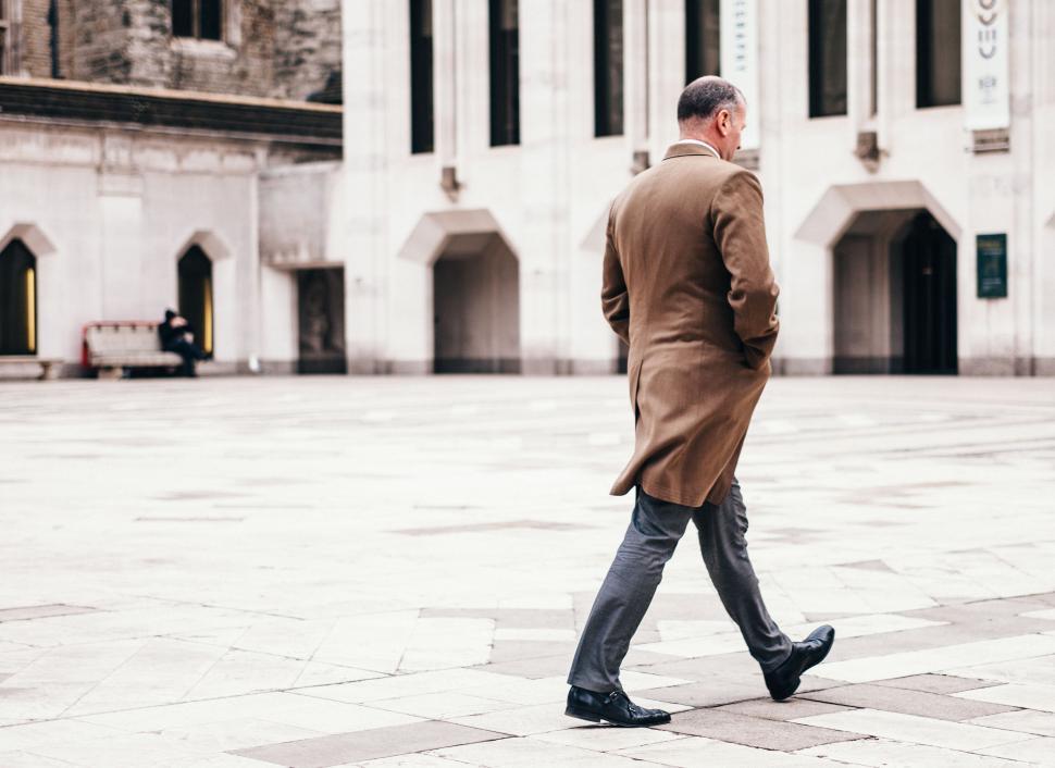 Free Image of Man in Brown Coat Walking Down Street 