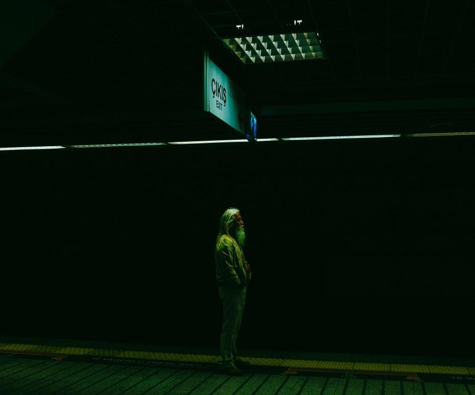 Free Image of Person Standing on Sidewalk in the Dark 