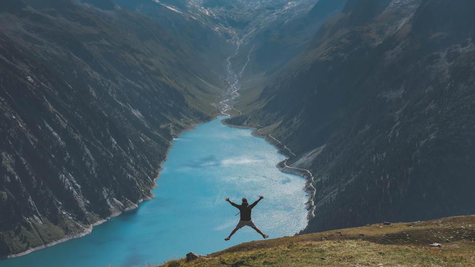 Free Image of Man Standing on Top of a Mountain by River 