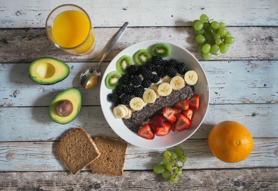 Free Image of Bowl of Fruit, Bread, and Glass of Orange Juice 
