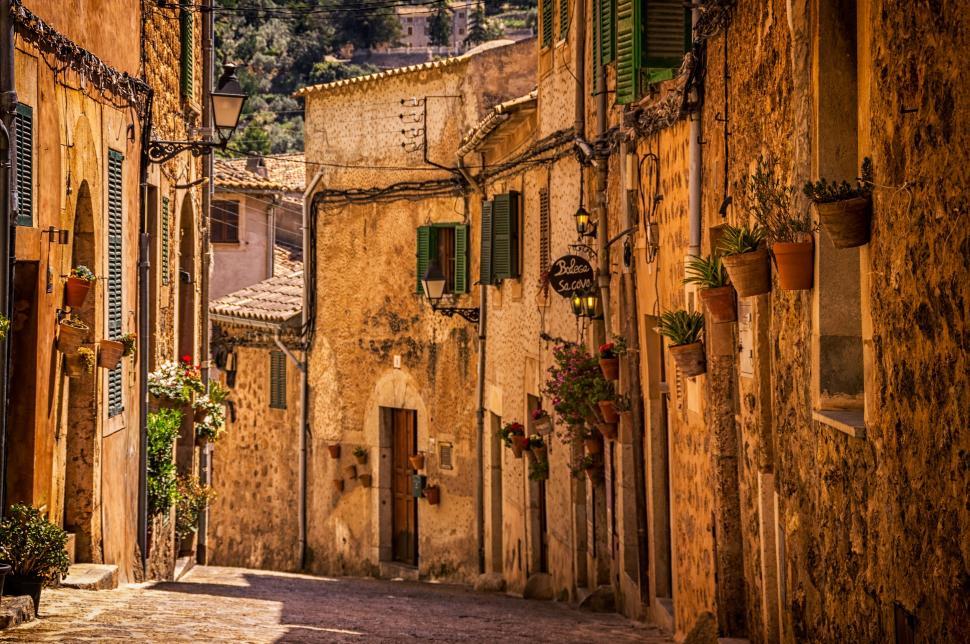 Free Image of Narrow Alleyway With Stone Buildings and Green Shutters 