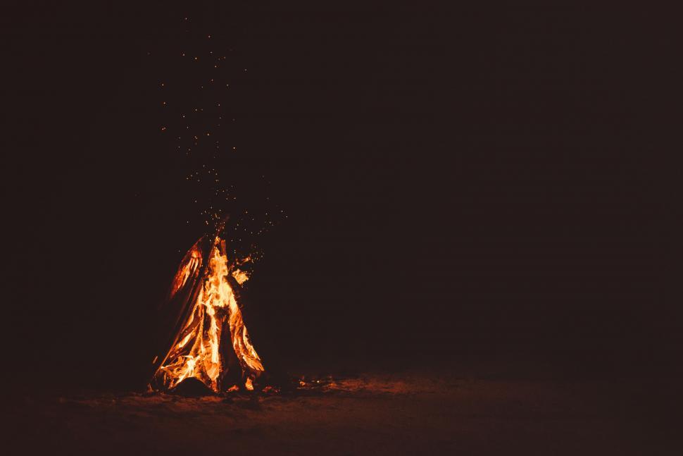 Free Image of Man Standing in Front of Fire in the Dark 