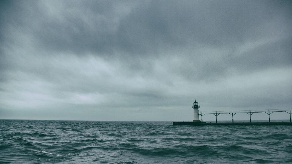 Free Image of Lighthouse Standing in Ocean Clouds 