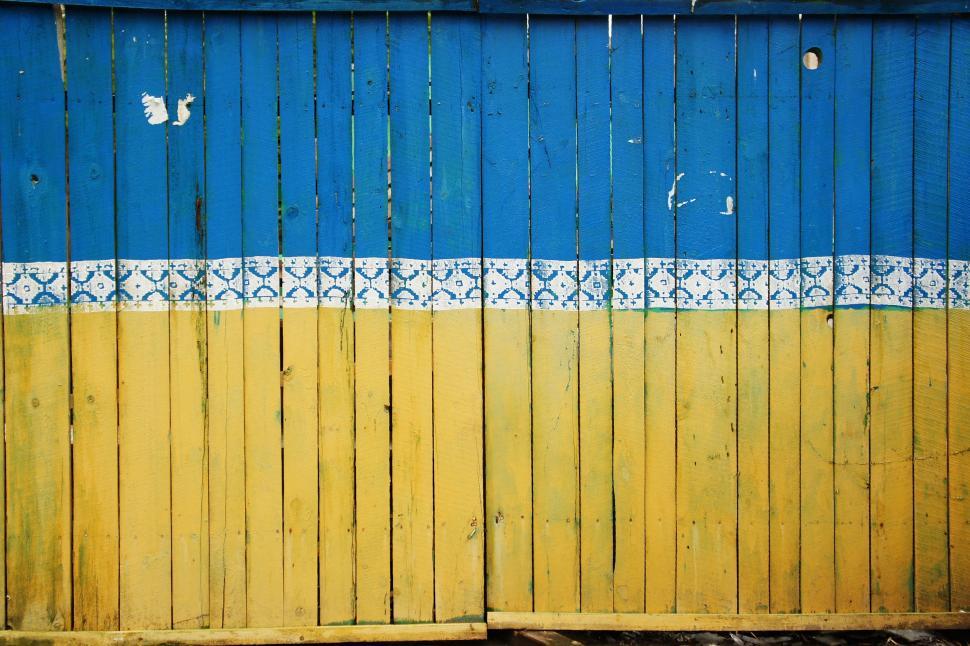 Free Image of Blue and Yellow Wall With Wooden Fence 