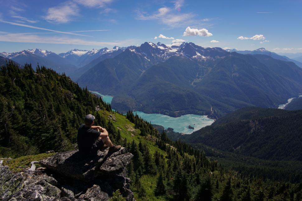 Free Image of Person Sitting on Top of Mountain Overlooking Lake 
