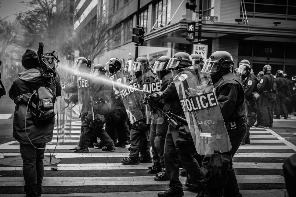 Free Image of Police Officers Spraying Water on Crowd 