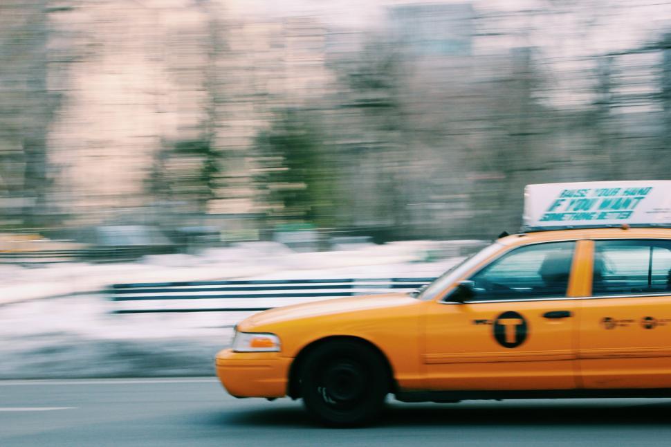 Free Image of Yellow Taxi Cab Driving Down a Street 