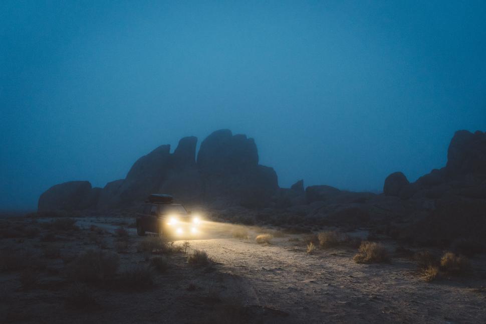 Free Image of Car Driving Down Dirt Road at Night 