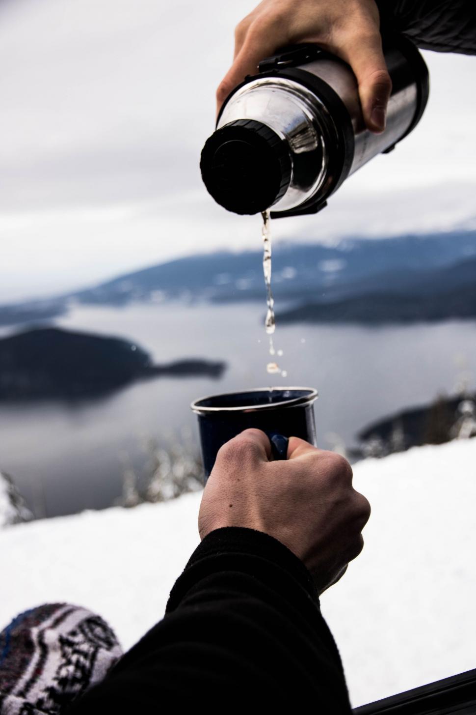 Free Image of Person Pouring Liquid Into Cup in Snow 