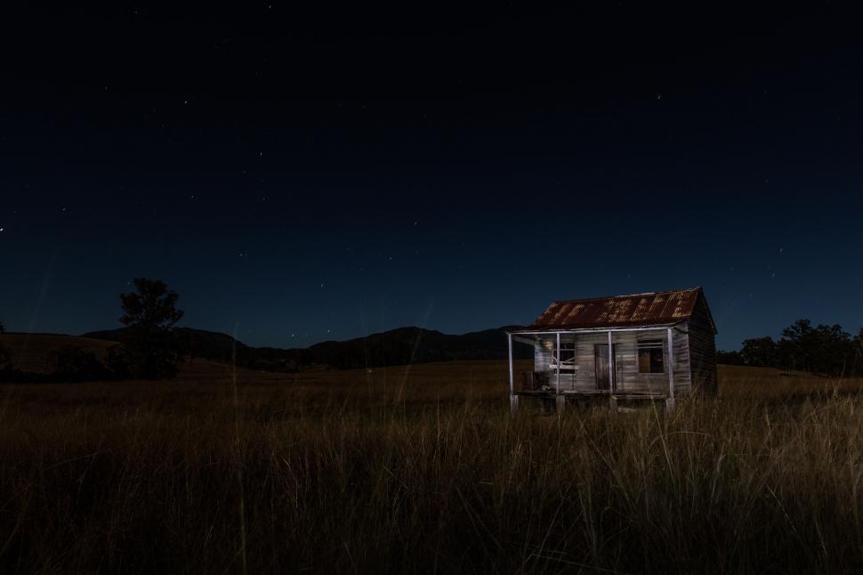 Free Image of House Illuminated by Moonlight in Field at Night 