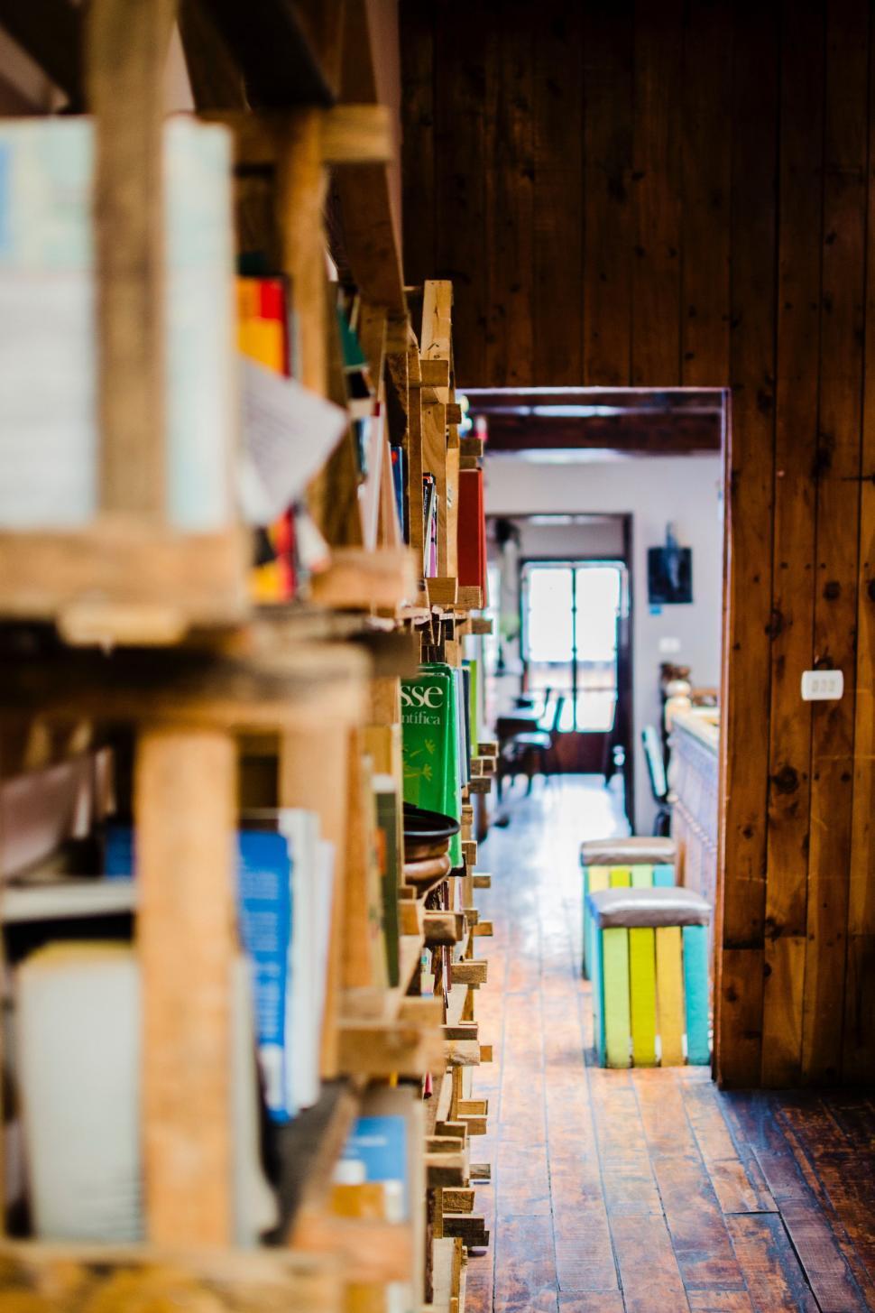 Free Image of Room Filled With Wooden Shelves Overflowing With Books 