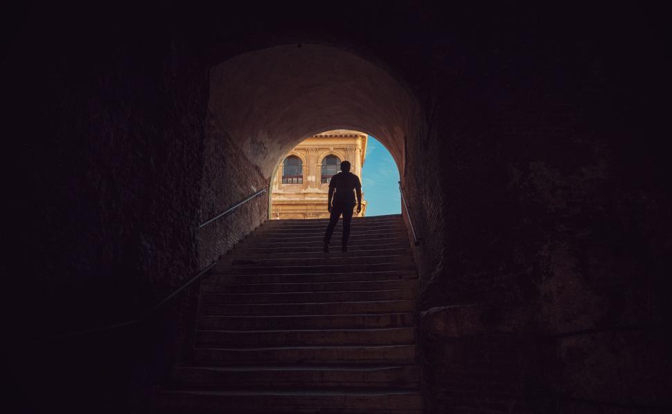 Free Image of Man Walking Up Stairs Into Tunnel 