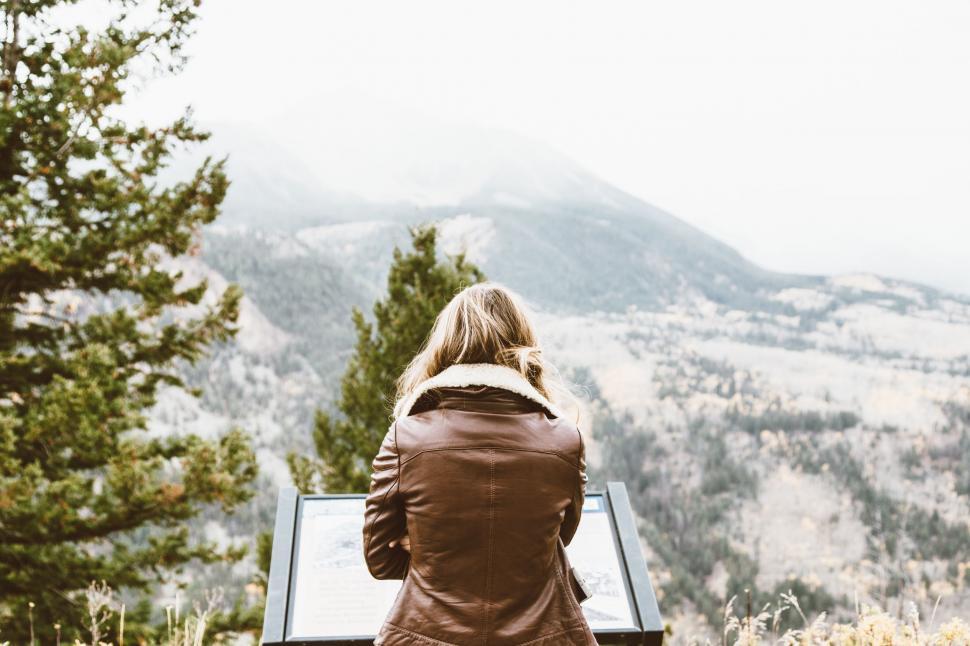 Free Image of Woman Sitting on Bench Looking at Mountains 