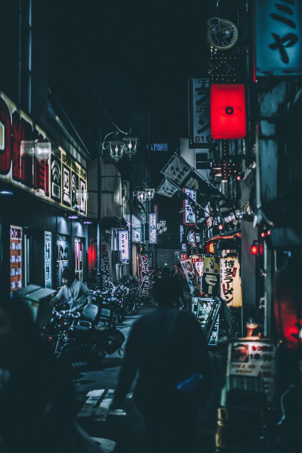 Free Image of Group of People Walking Down a Street at Night 