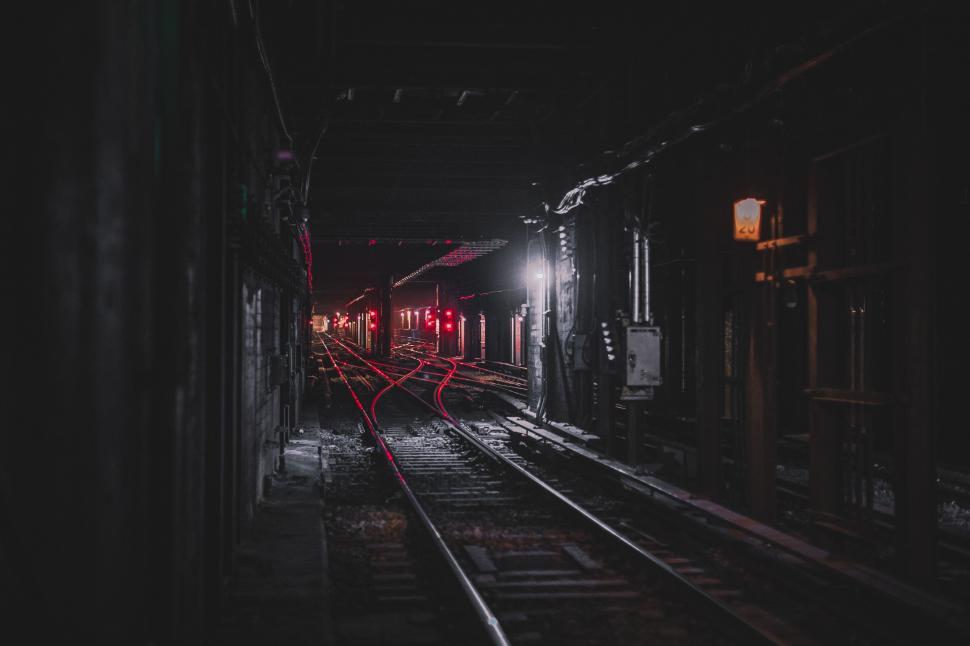Free Image of Train Traveling Down Train Tracks at Night 