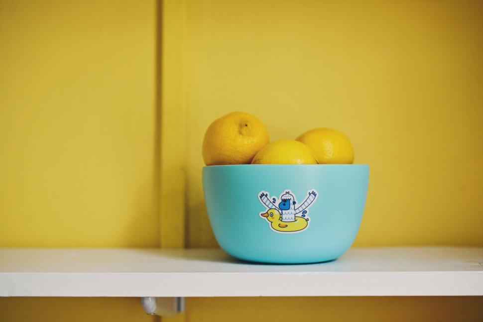 Free Image of Blue Bowl Filled With Lemons on White Shelf 