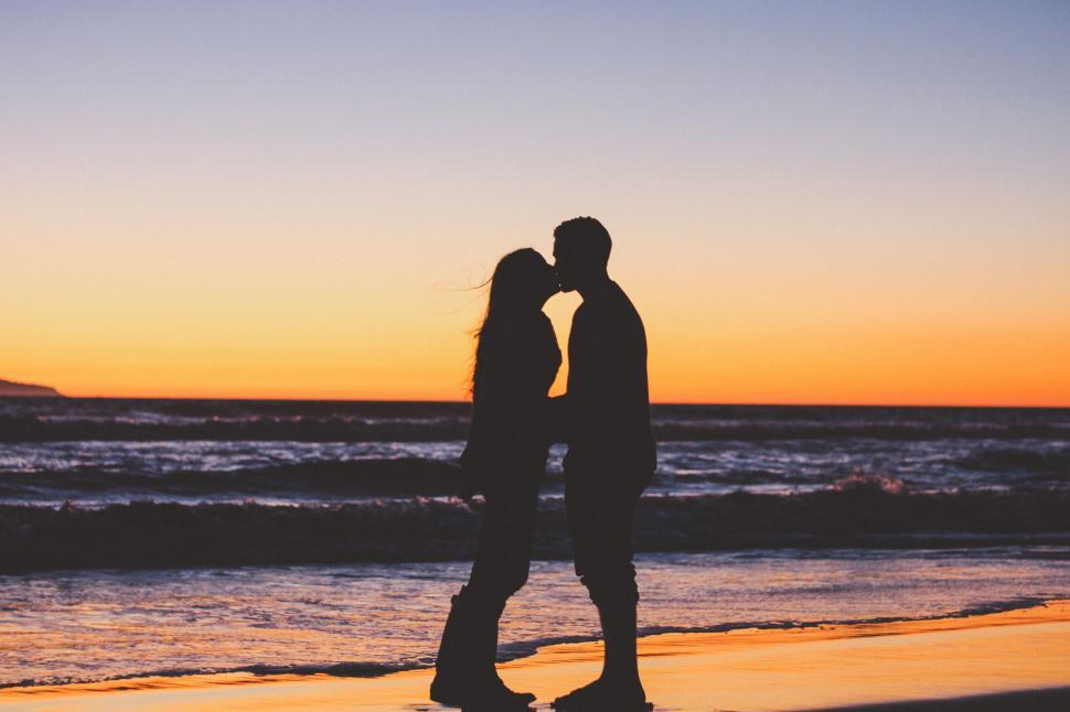 Free Image of A Couple Kissing on the Beach at Sunset 