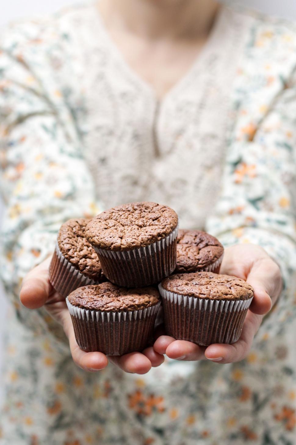 Free Image of Woman Holding a Bunch of Cupcakes 