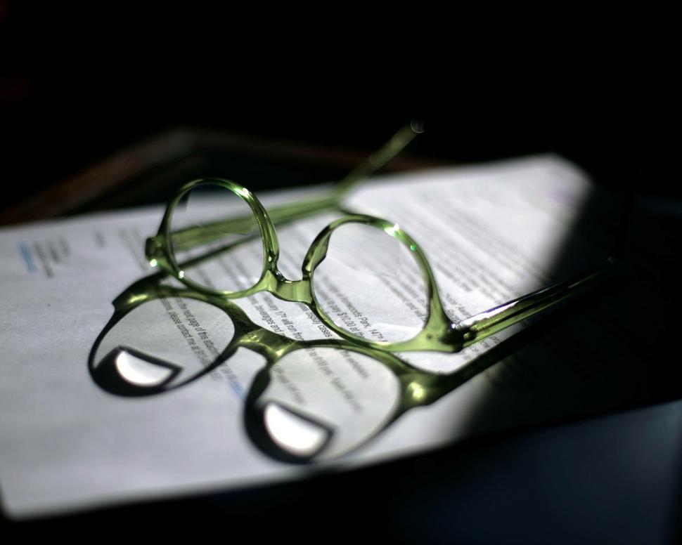 Free Image of Glasses Resting on Top of Paper 