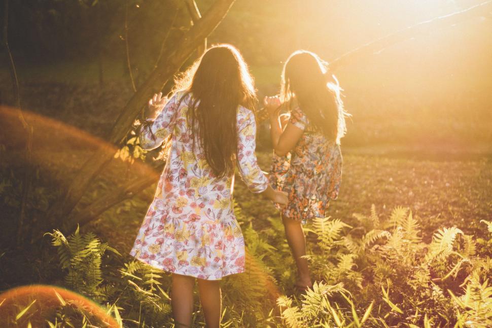 Free Image of Two Girls Walking Through Tall Grass Field 