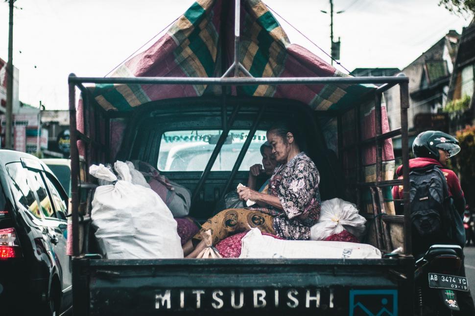 Free Image of Woman Sitting in the Back of a Truck 