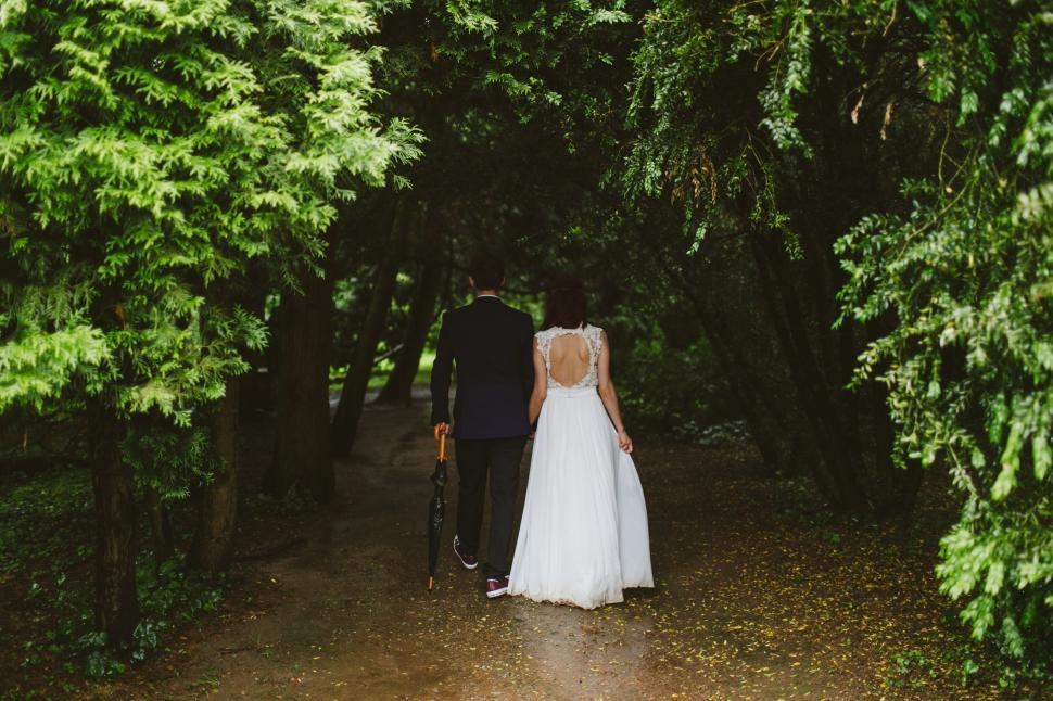 Free Image of Bride and Groom Walking Down a Path in the Woods 