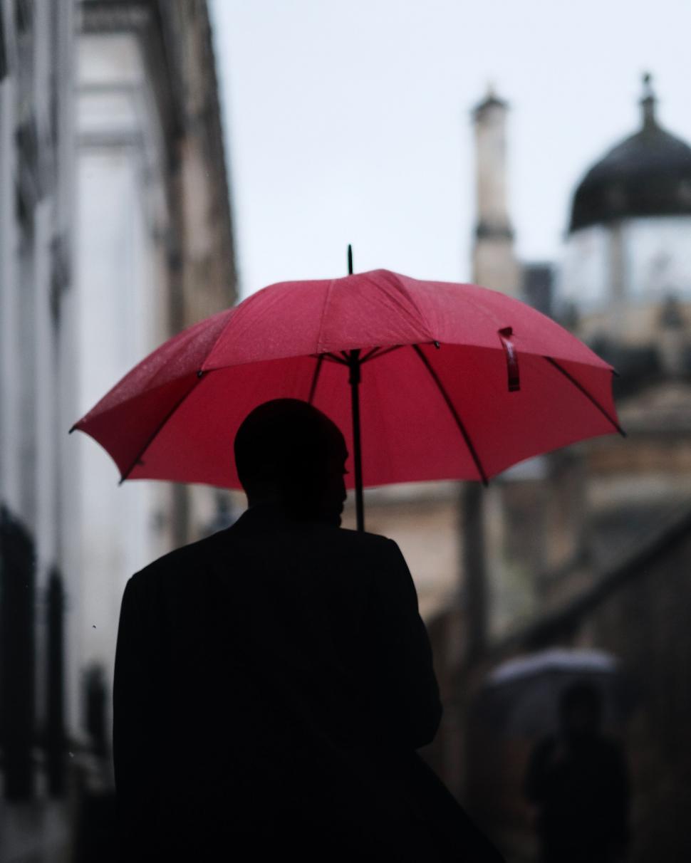 Free Image of Silhouette of Man Holding Red Umbrella 