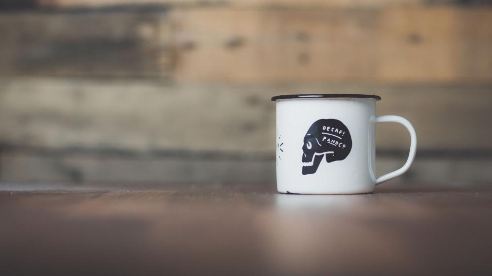Free Image of White and Black Coffee Mug With Skull Design 