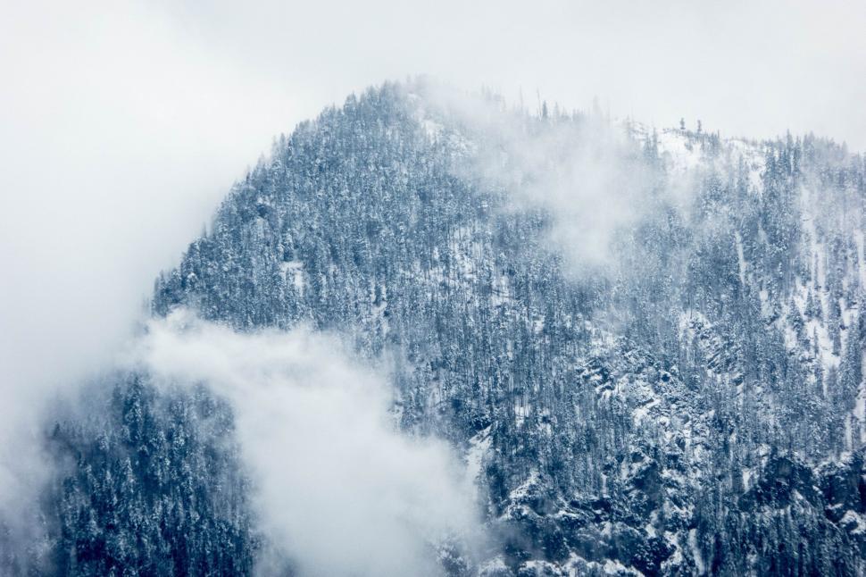Free Image of Snow-Covered Mountain Blanketed in Fog 