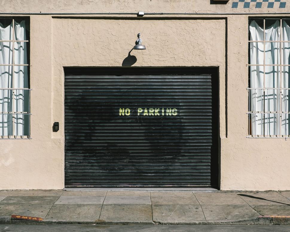 Free Image of Black Garage Door With No Parking Sign 