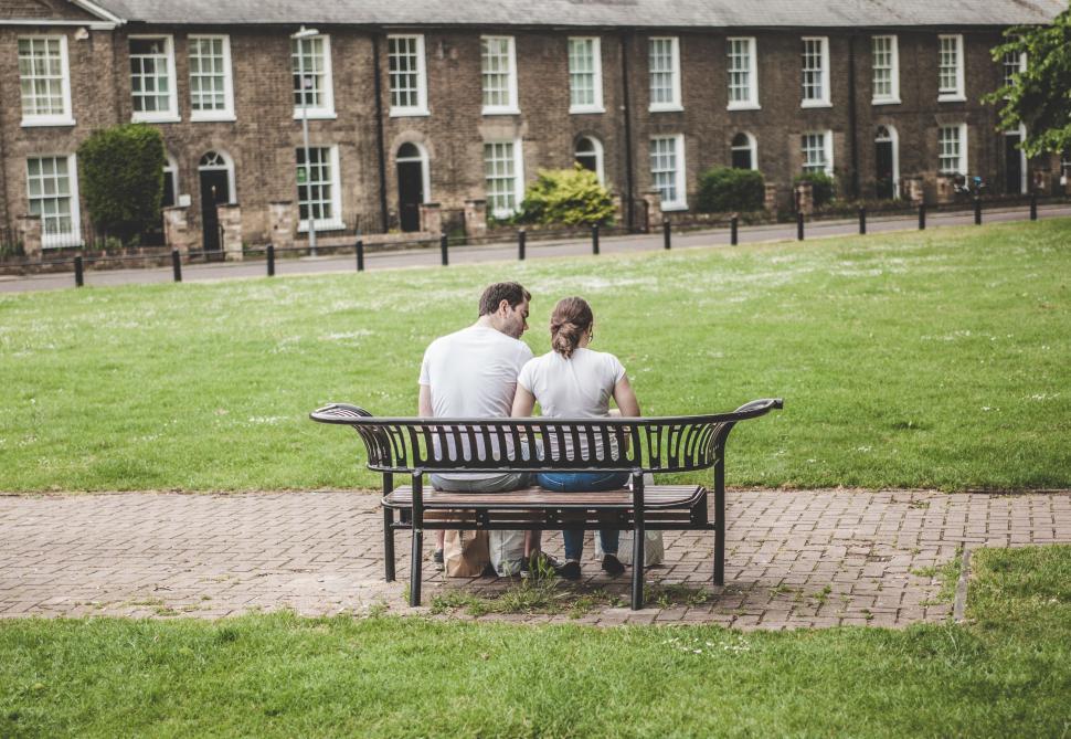 Free Image of Two Men Sitting on a Bench in Front of a Building 