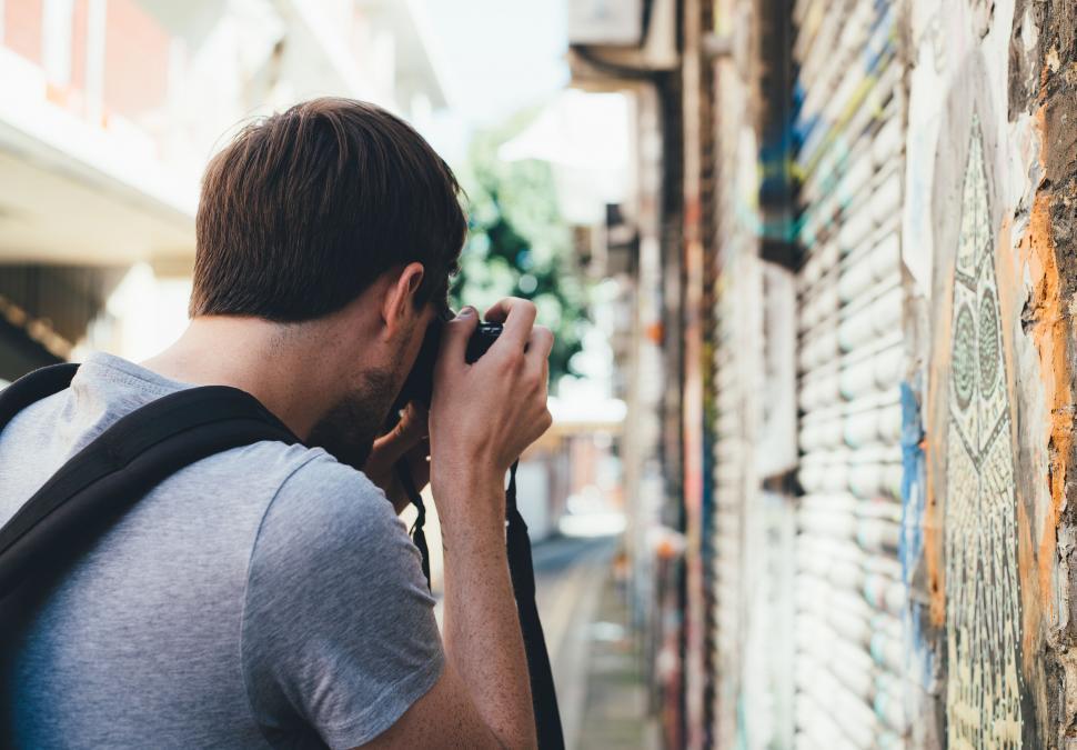 Free Image of Man With Backpack Using Cell Phone 