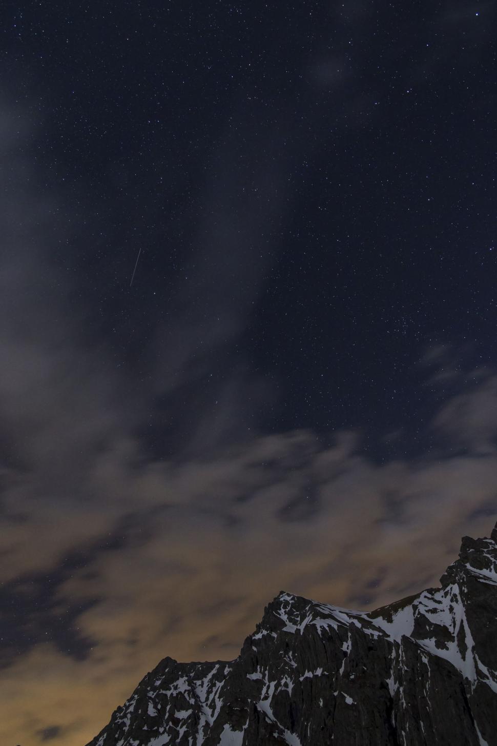 Free Image of Night Sky With Stars and Clouds Over a Mountain 