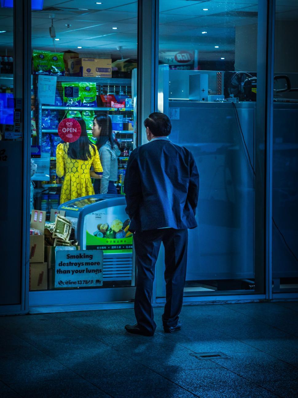 Free Image of Man Standing in Front of Store at Night 