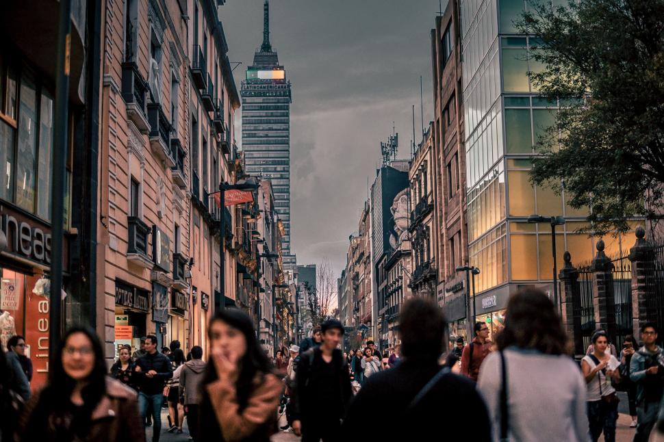 Free Image of People Walking Down Street Next to Tall Buildings 