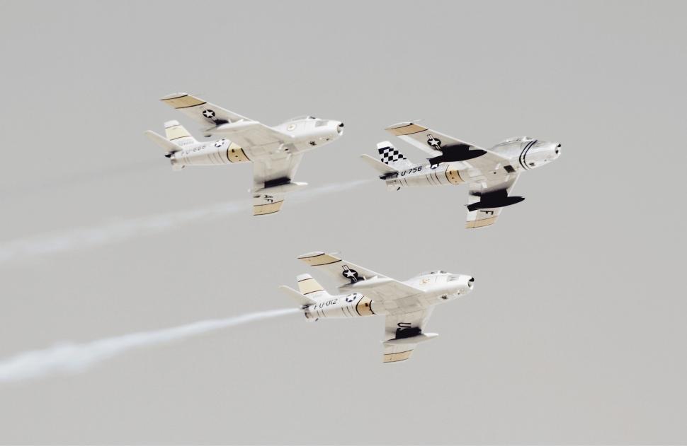 Free Image of Group of Fighter Jets Flying Through Cloudy Sky 