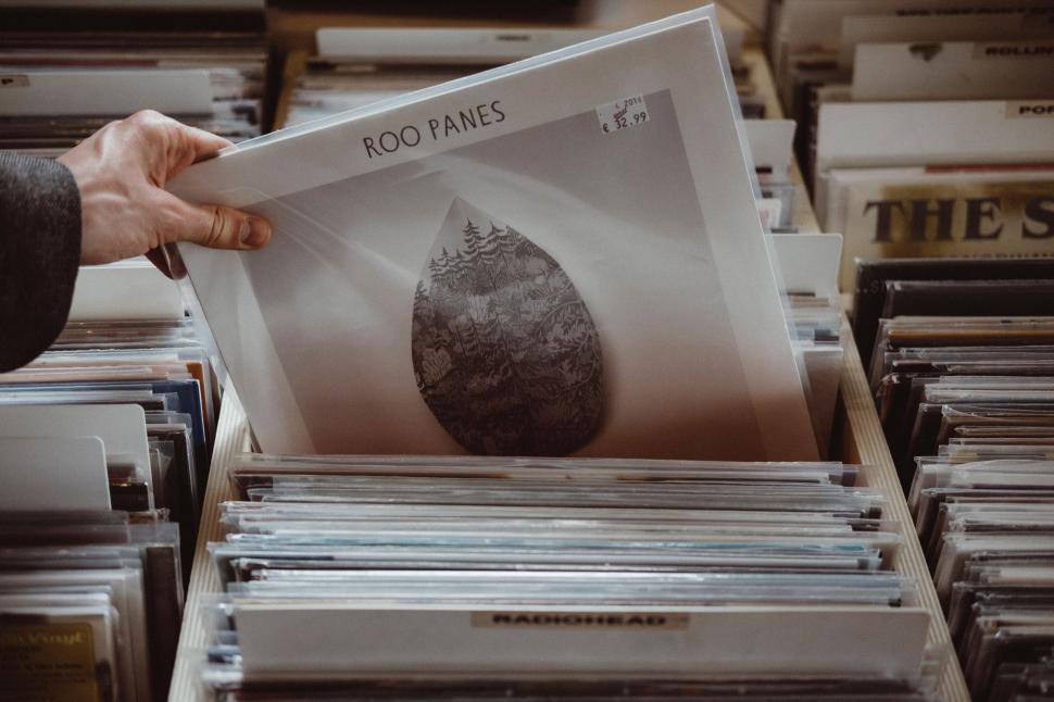 Free Image of Person Holding Up a Record Among Many Records 