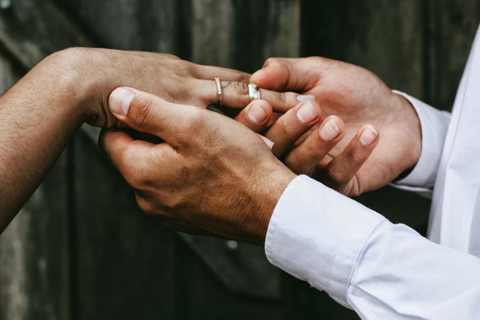 Free Image of Man and Woman Holding Hands With Wedding Rings 