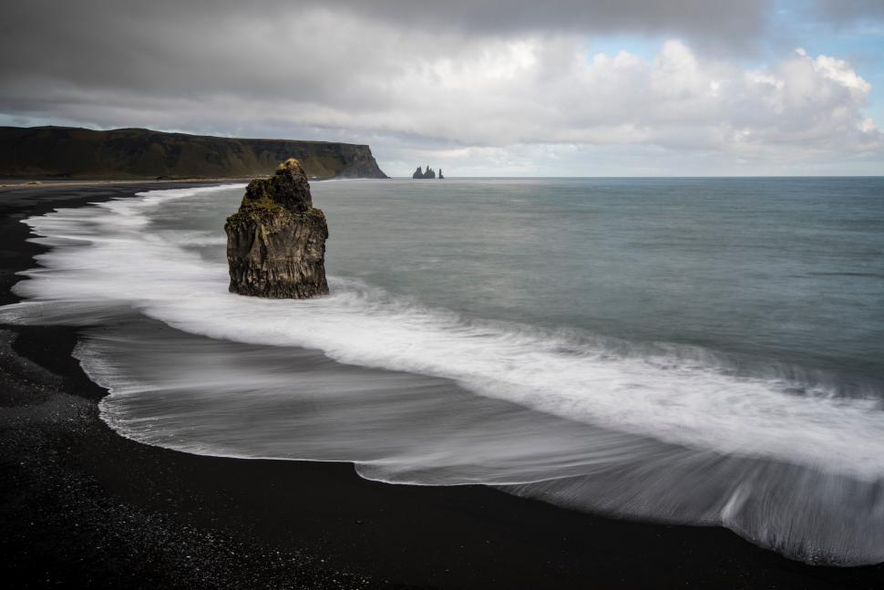 Free Image of Black Sand Beach With Rock Formation in Water 