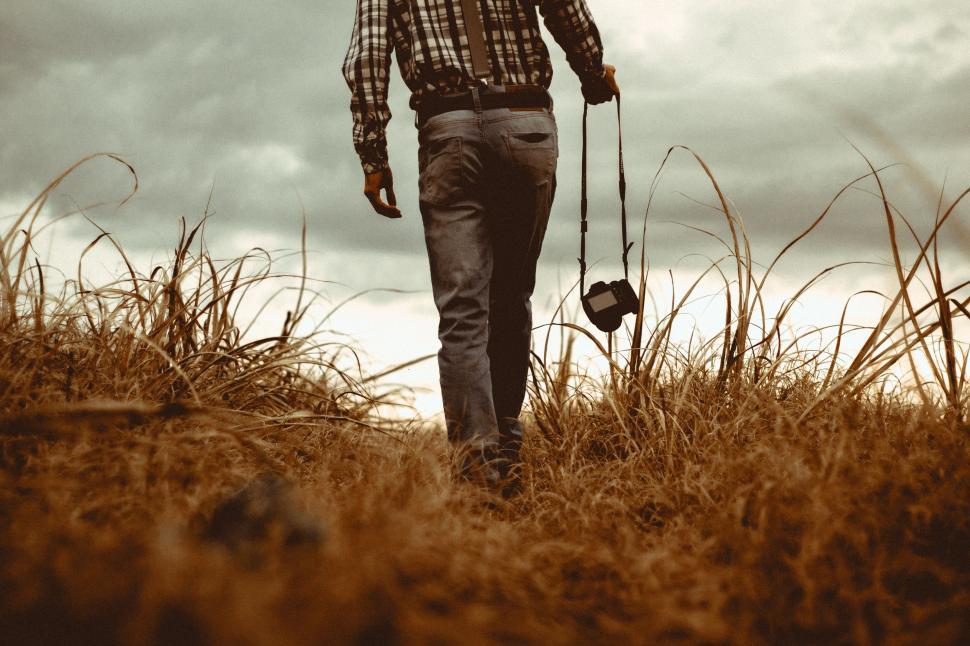 Free Image of Man Walking Through Field With Dog 